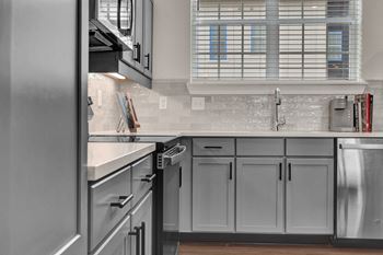 A modern kitchen with stainless steel appliances and a subway tile backsplash.